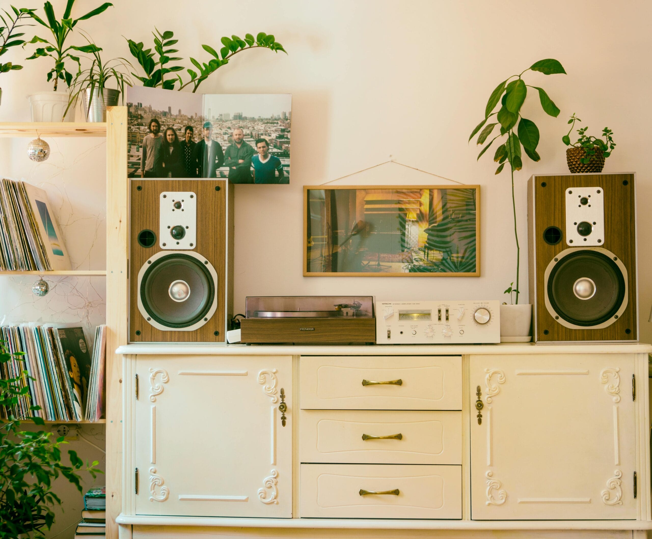 Retro home interior featuring vintage stereo, speakers, and houseplants for cozy atmosphere.